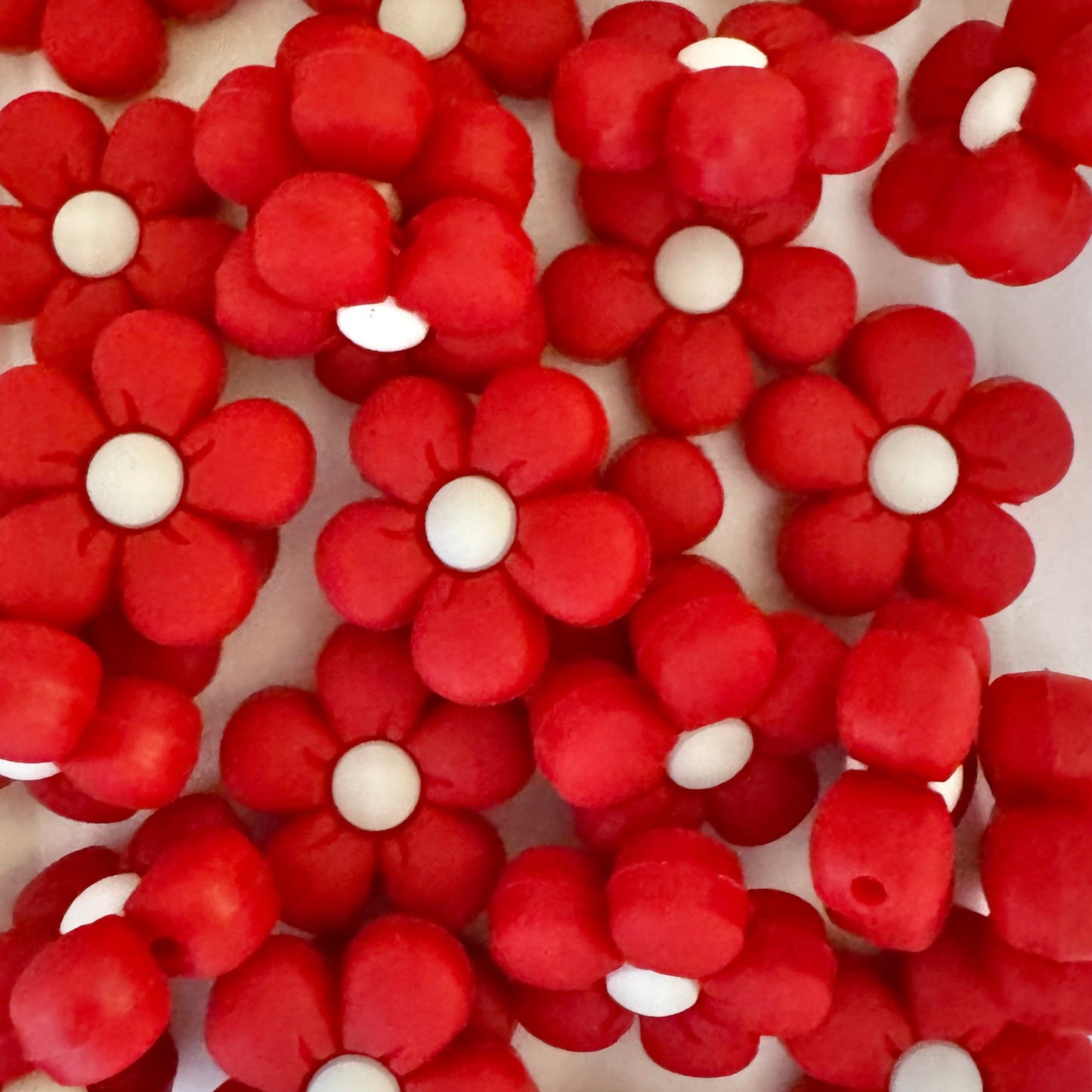 Red flowers with white centers on a white background