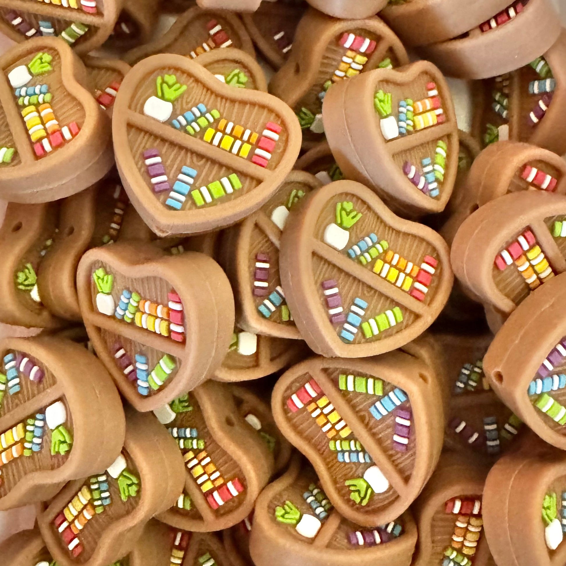 Stack of heart-shaped wooden toys with colorful mosaic designs on a white background