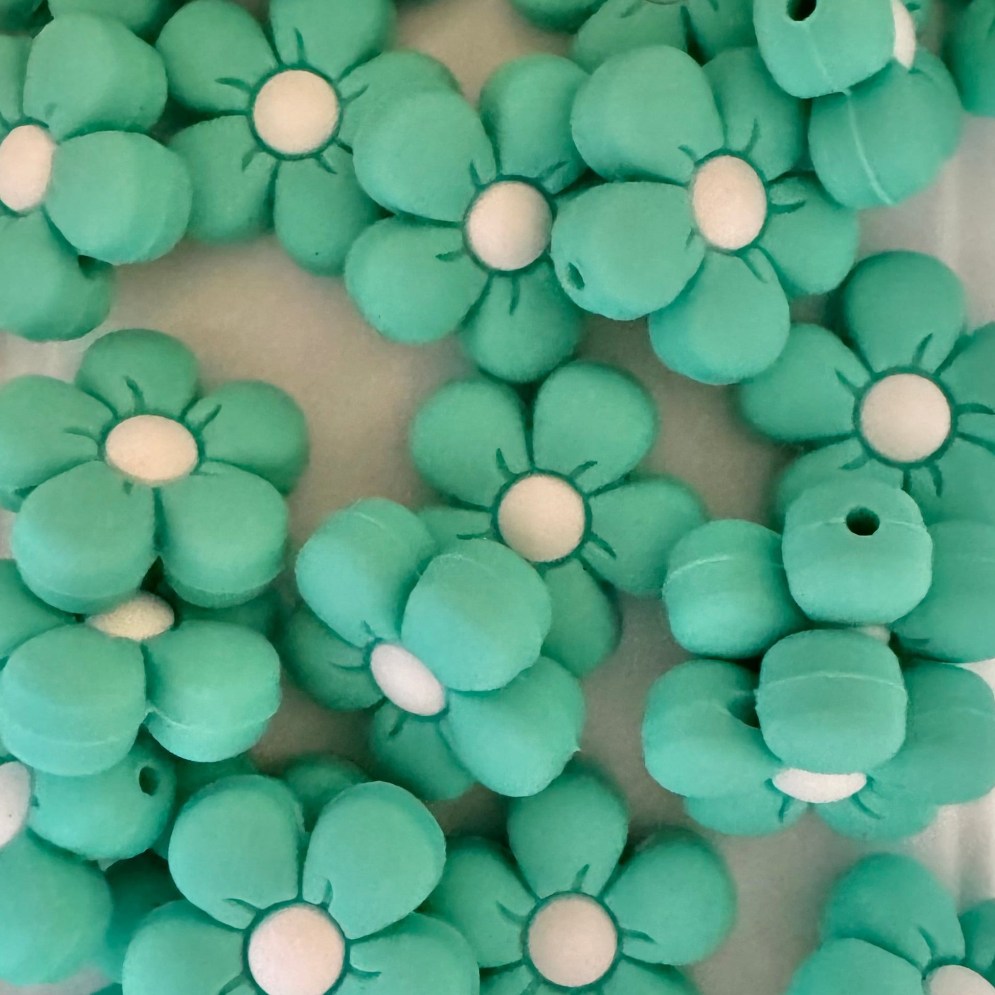 Green flower-shaped beads on a white background