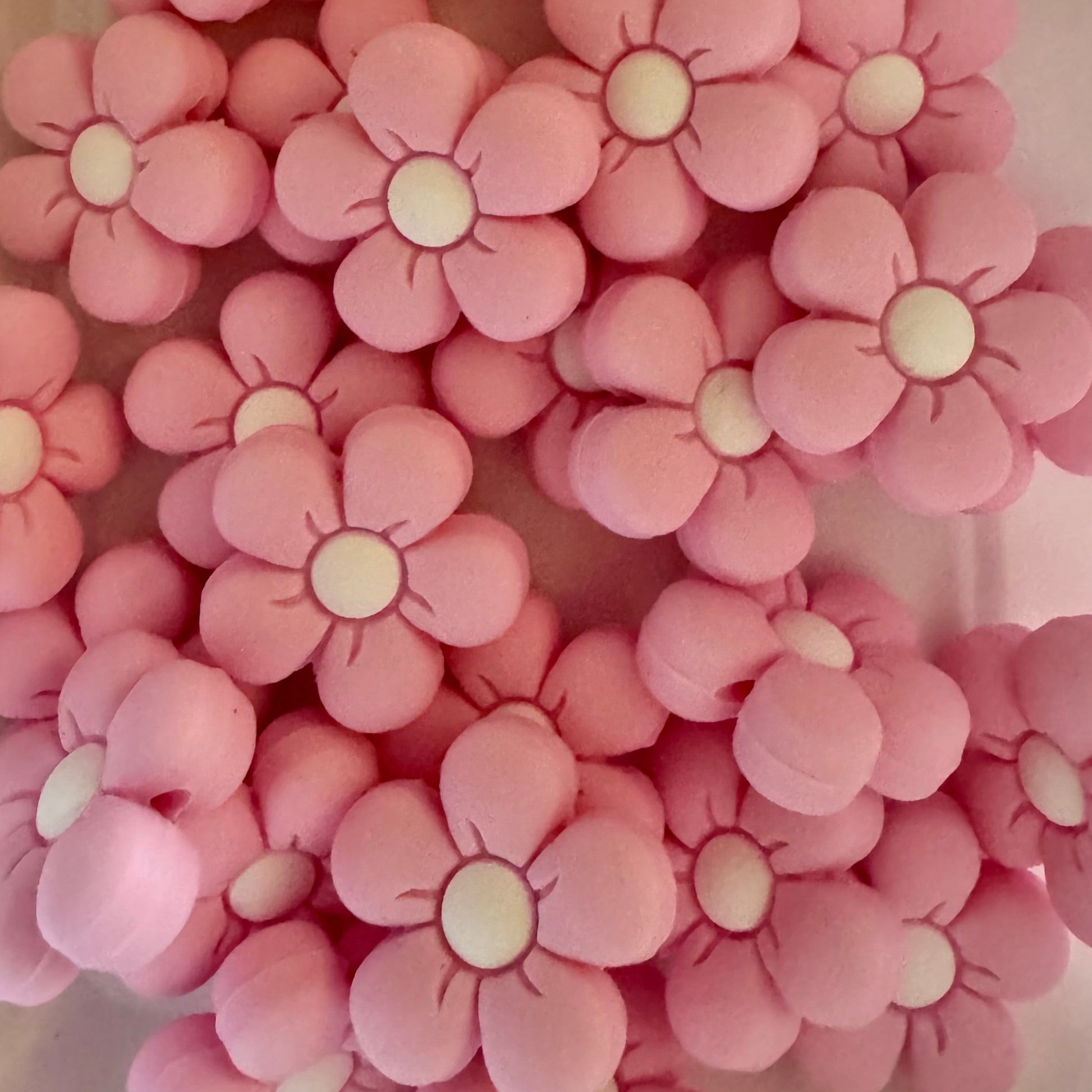 Pink flower-shaped objects on a light pink background