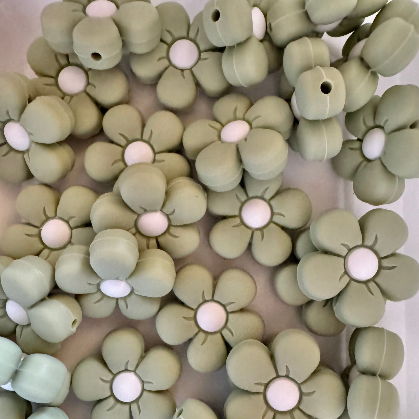 Close-up of green floral-shaped objects with white centers on a white background