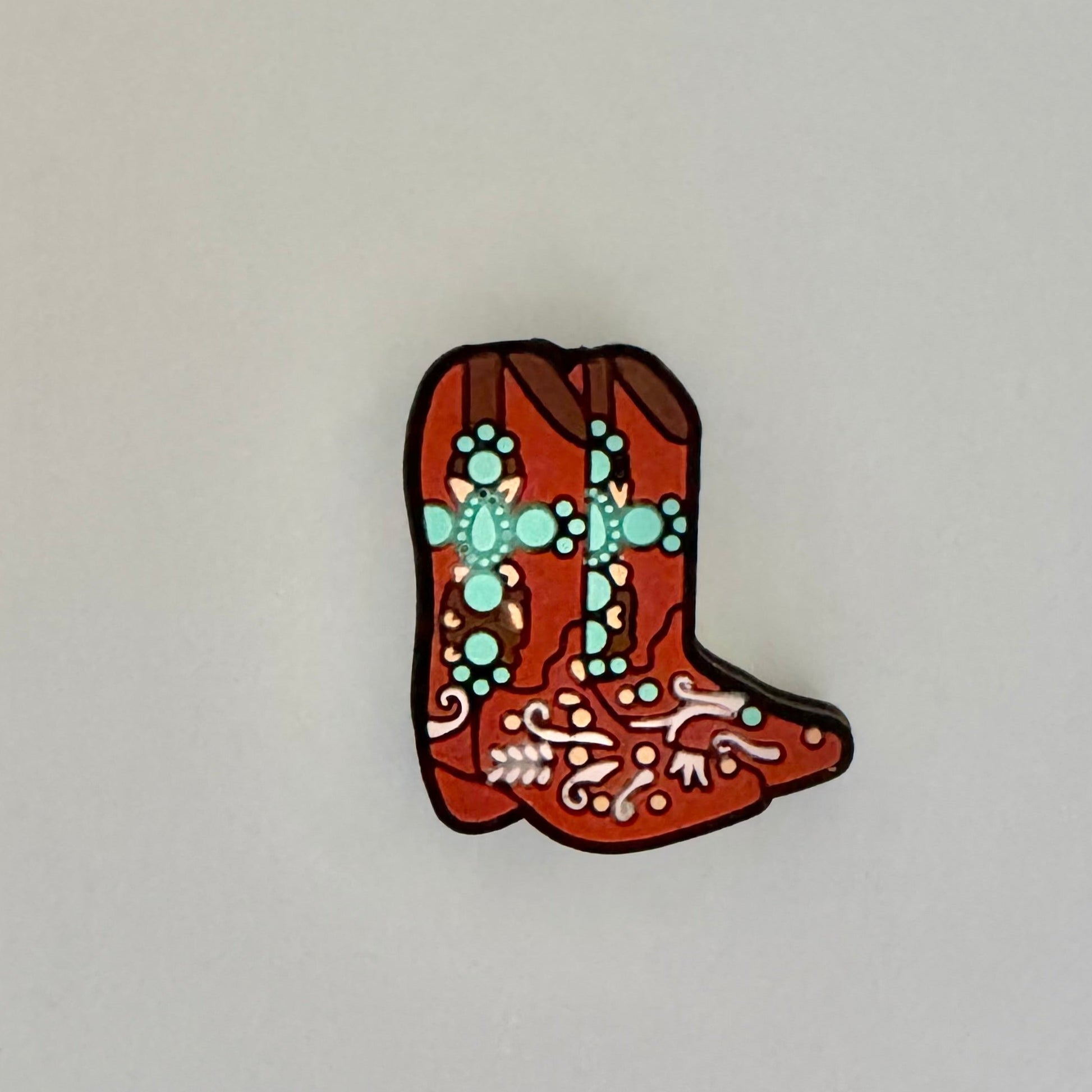 Decorative boot-shaped object with intricate patterns on a white background