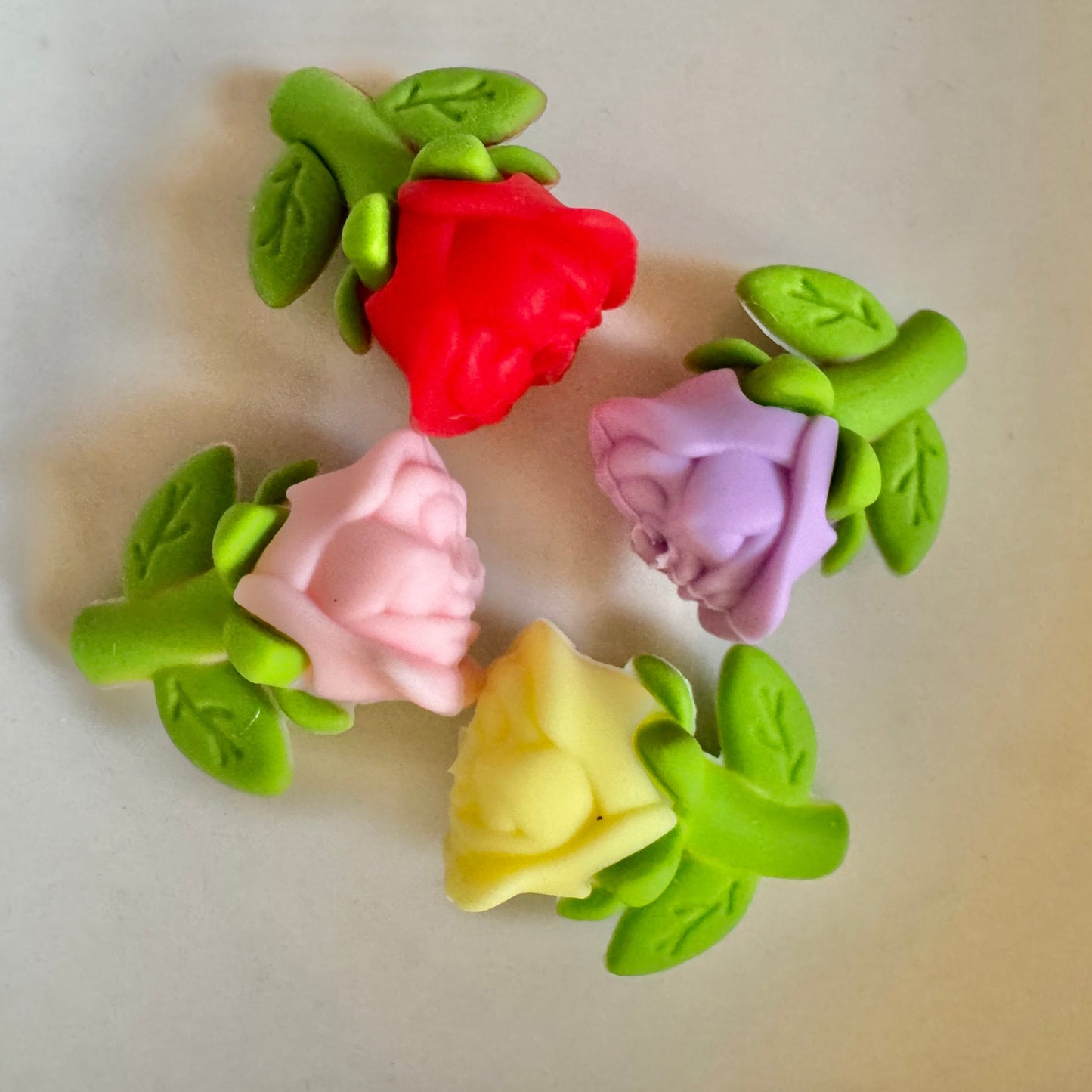 Colorful flower-shaped beads on a plain background