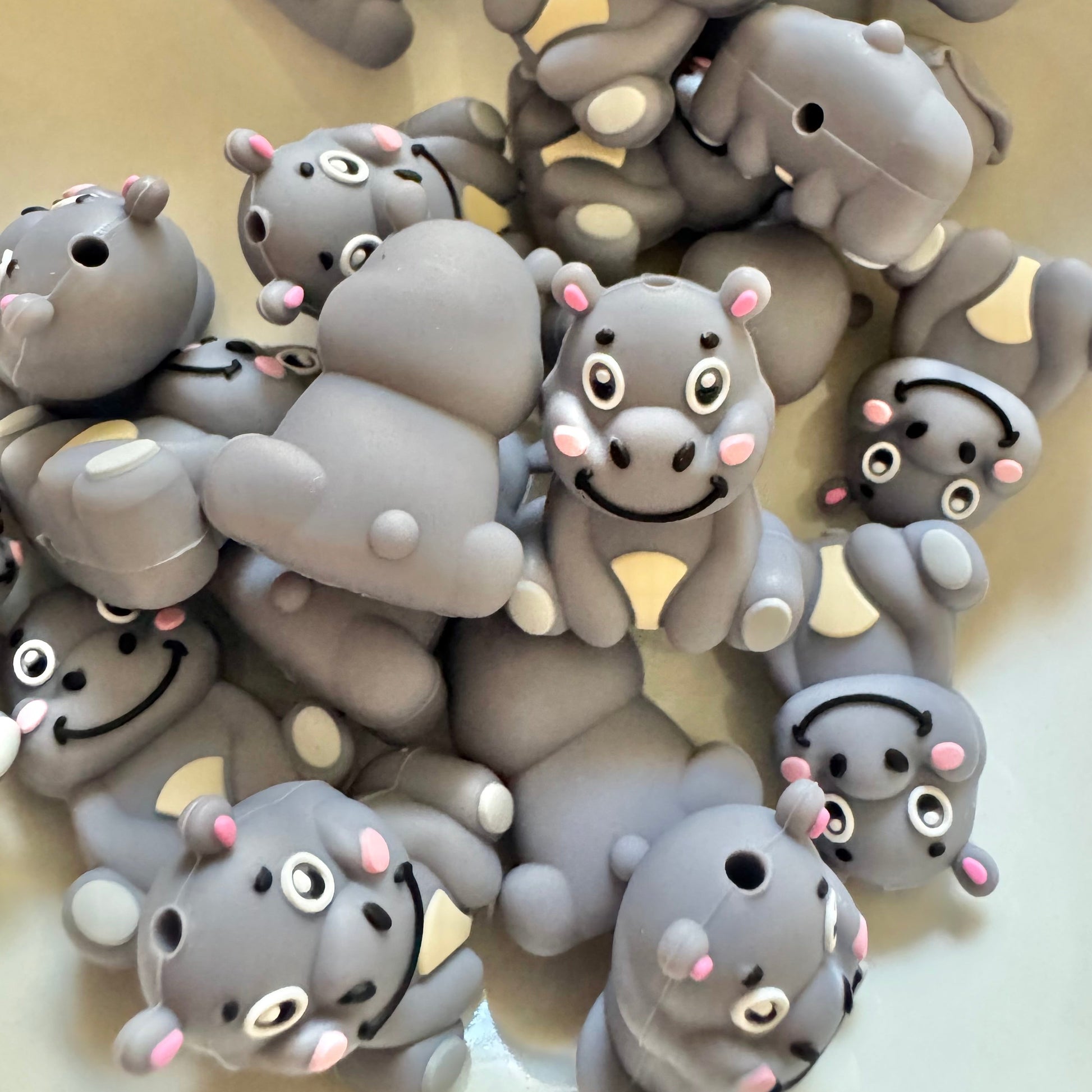 Collection of gray hippo bead with pink accents on a light background