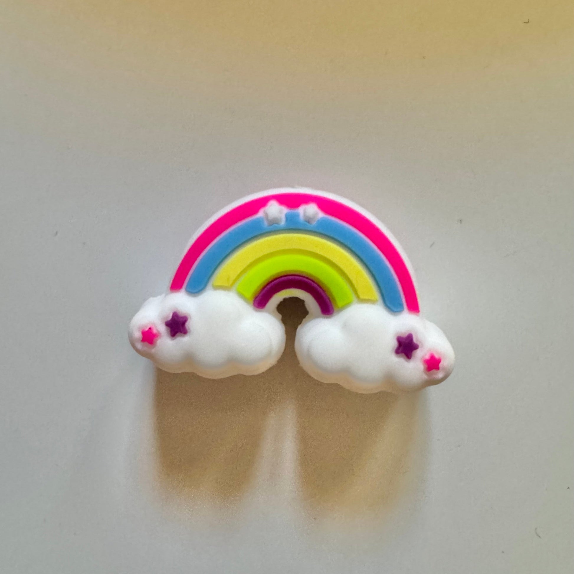 Colorful rainbow and cloud design on a plain background