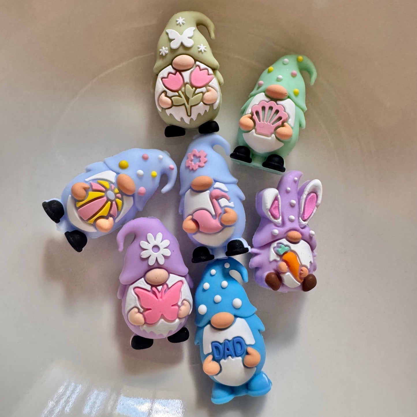 Set of colorful gnome figurines on a beige surface