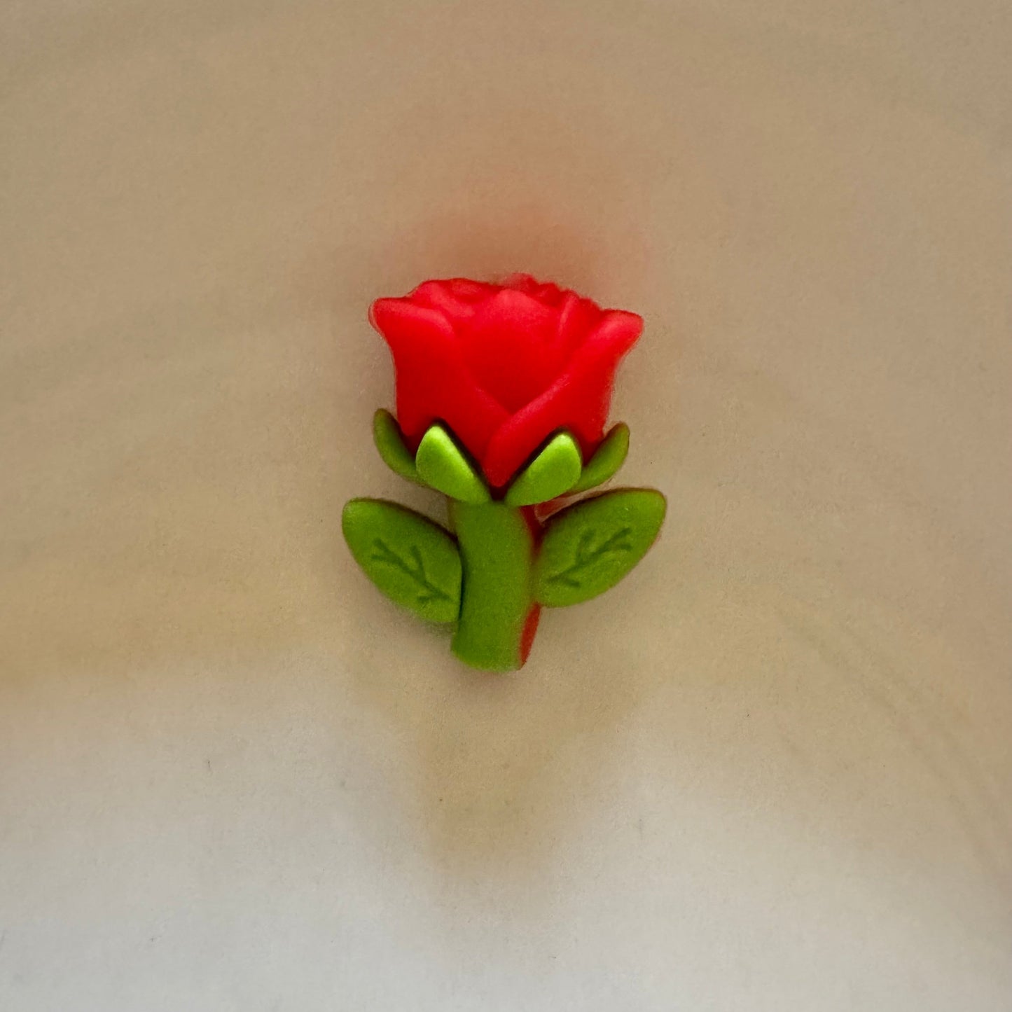Red rose-shaped object on a beige background