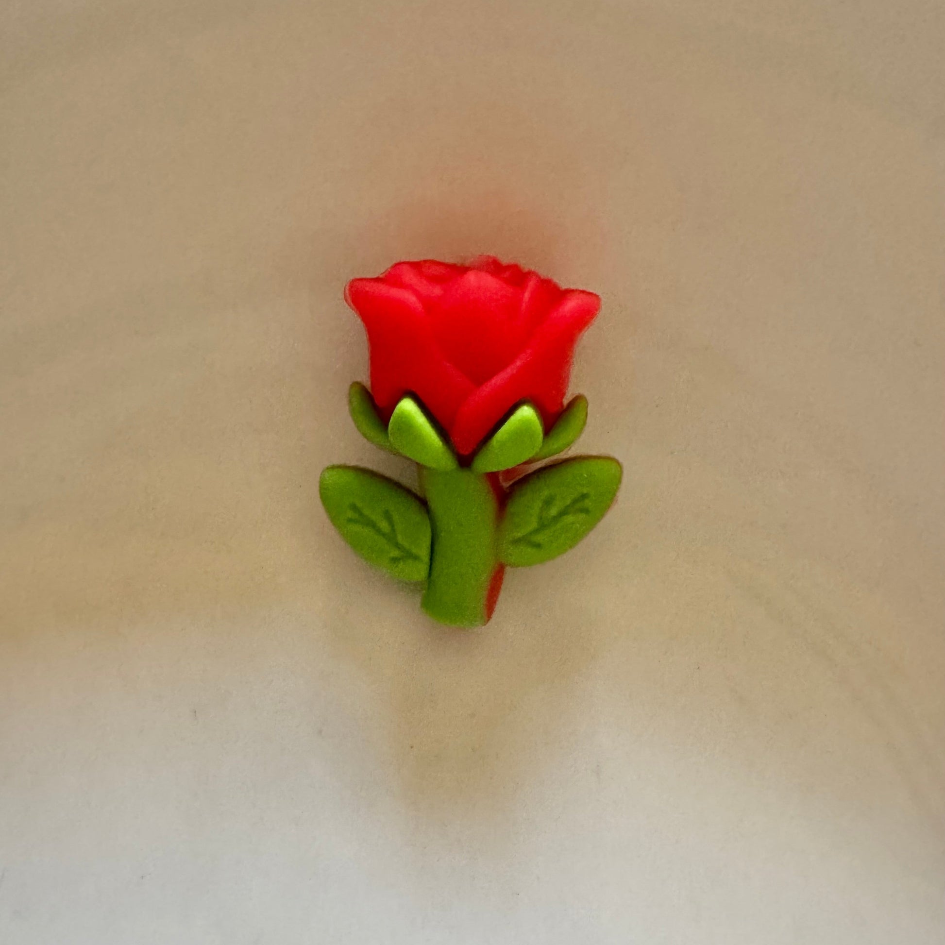 Red rose-shaped object on a beige background