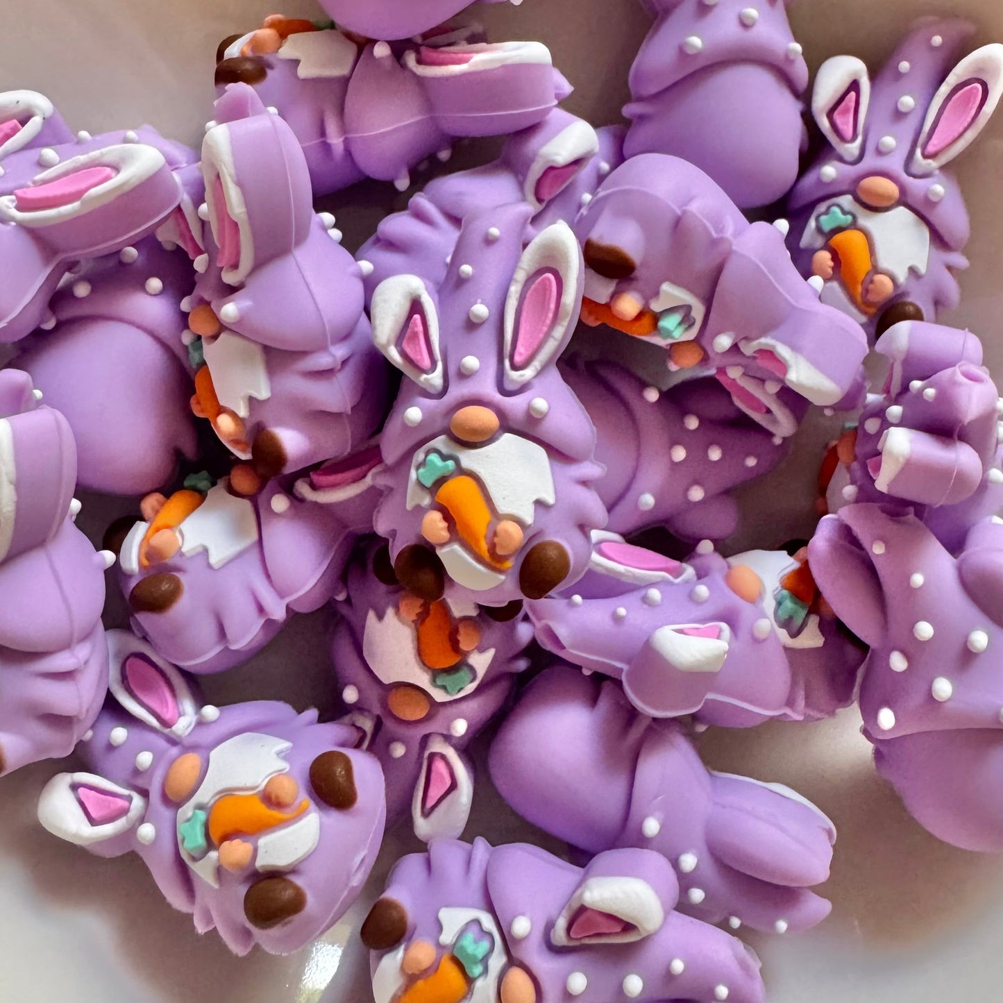 Purple bunny-shaped gnome with decorative elements on a white surface