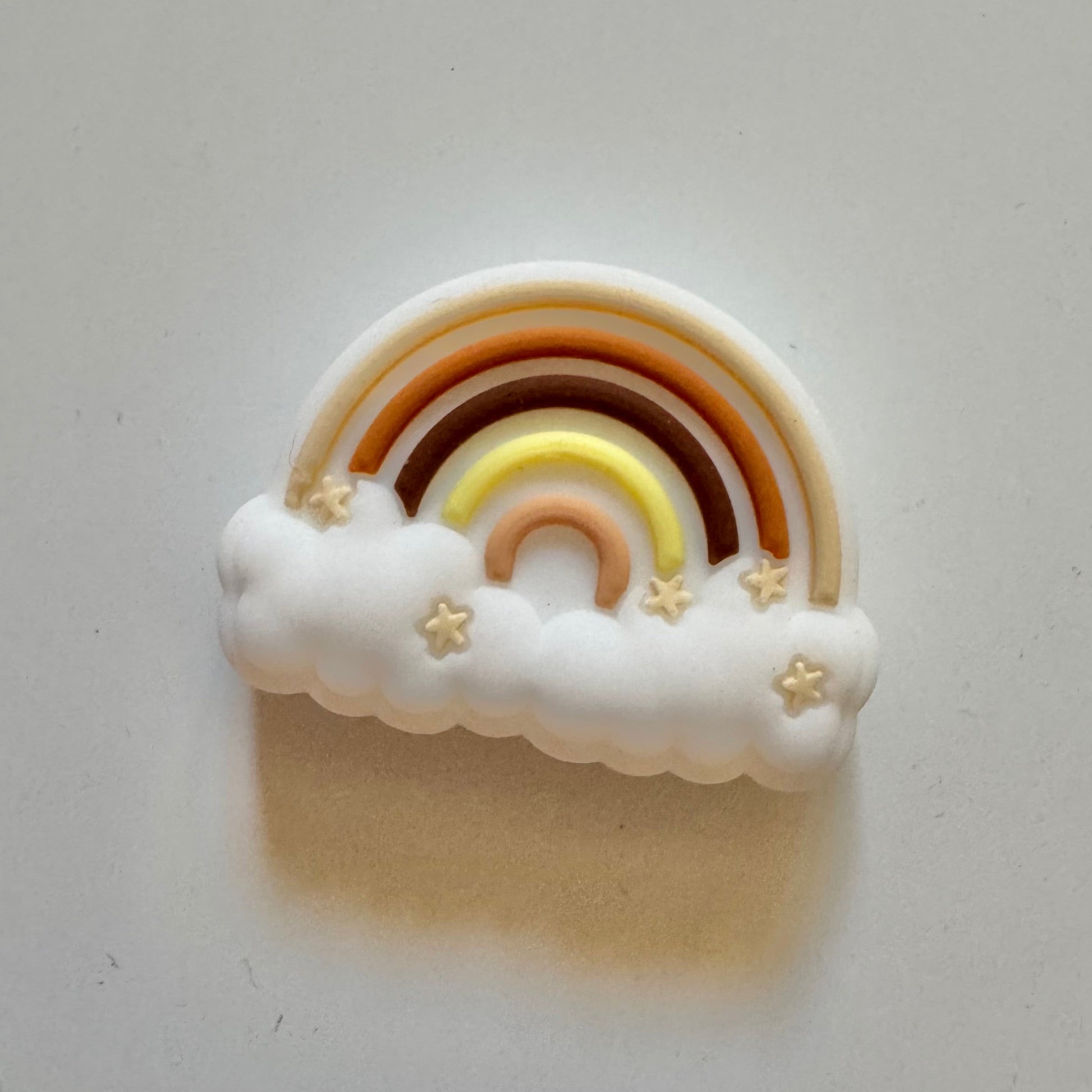 Decorative rainbow and cloud charm on a white background