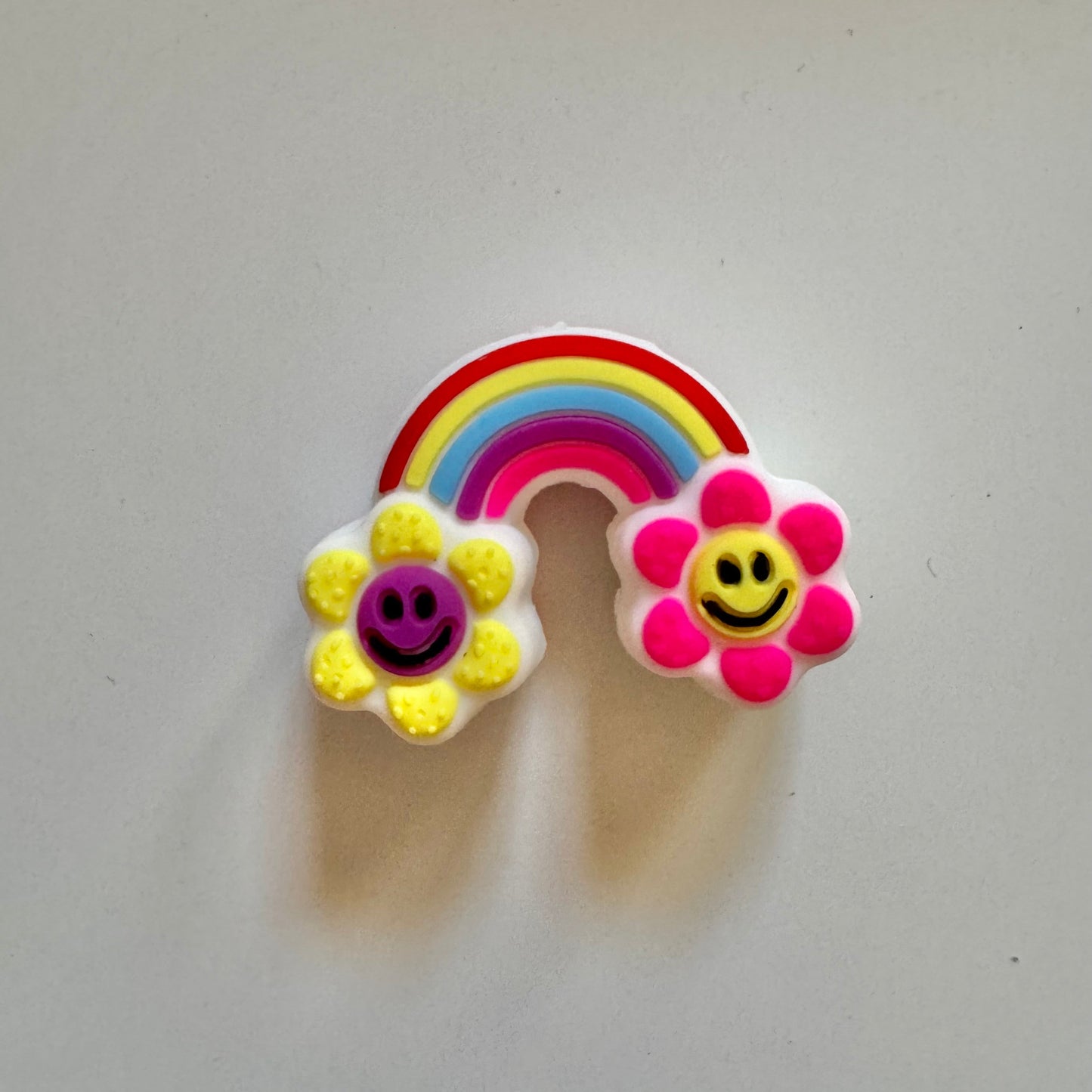 Colorful rainbow and flower-shaped bead on a light gray background